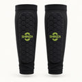 Pair of Shinza black football shin pad compression sleeves with hexagonal padded panel and printed lime green Shinza logo, front view on white background